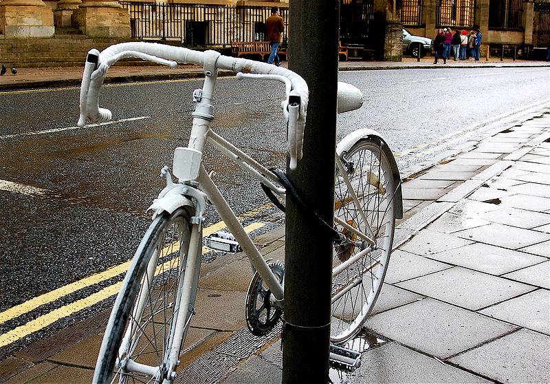 A white "Ghost Bike" chained to a post where a bicyclist died in Arizona