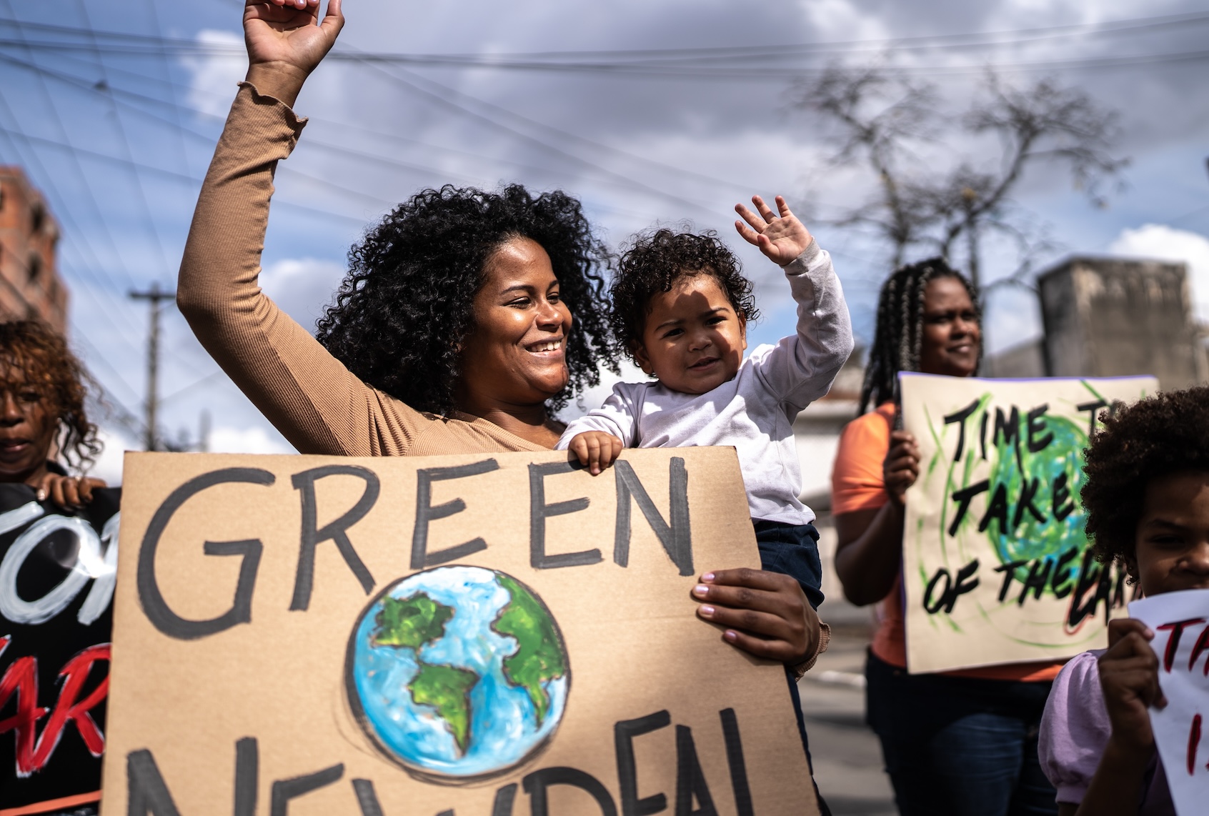 Young woman with her son protesting in the street. (Getty Images / FG Trade)