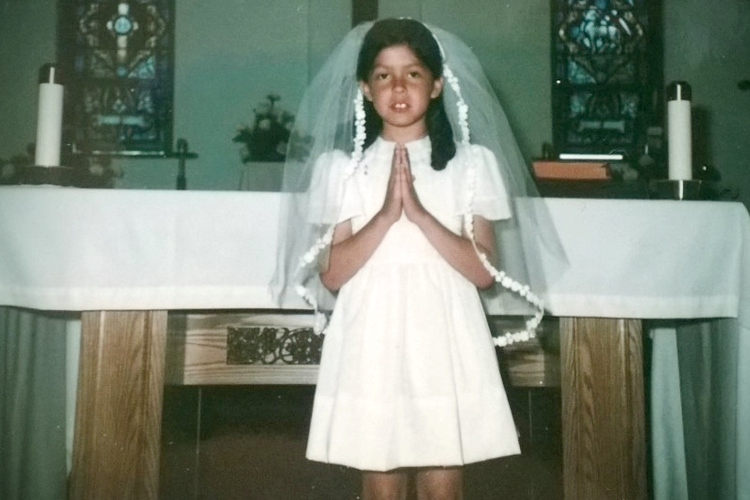 A photo of the author at her First Communion