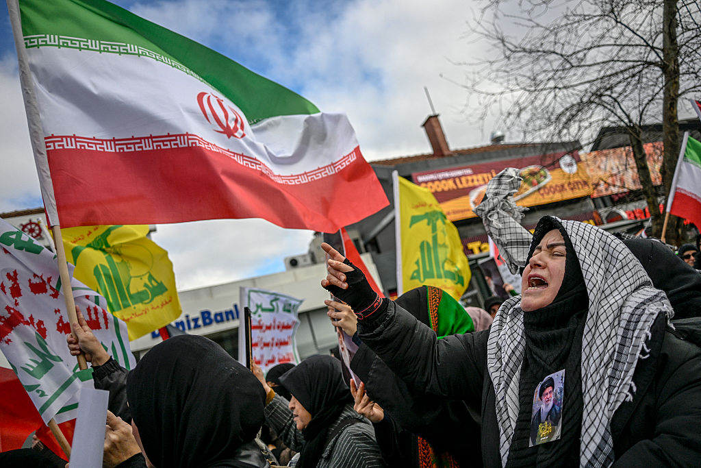 A protestor displaying a portrait of Ayatollah Ali Khamenei on her clothes gestures during a demonstration against the US and Israel attack of Iran and the killing of the Supreme leader. The growing conflict sparks fears of regional war with explosions reported across the Middle East as the Islamic republic retaliated with barrages of missiles. (OZAN KOSE / Getty Images)