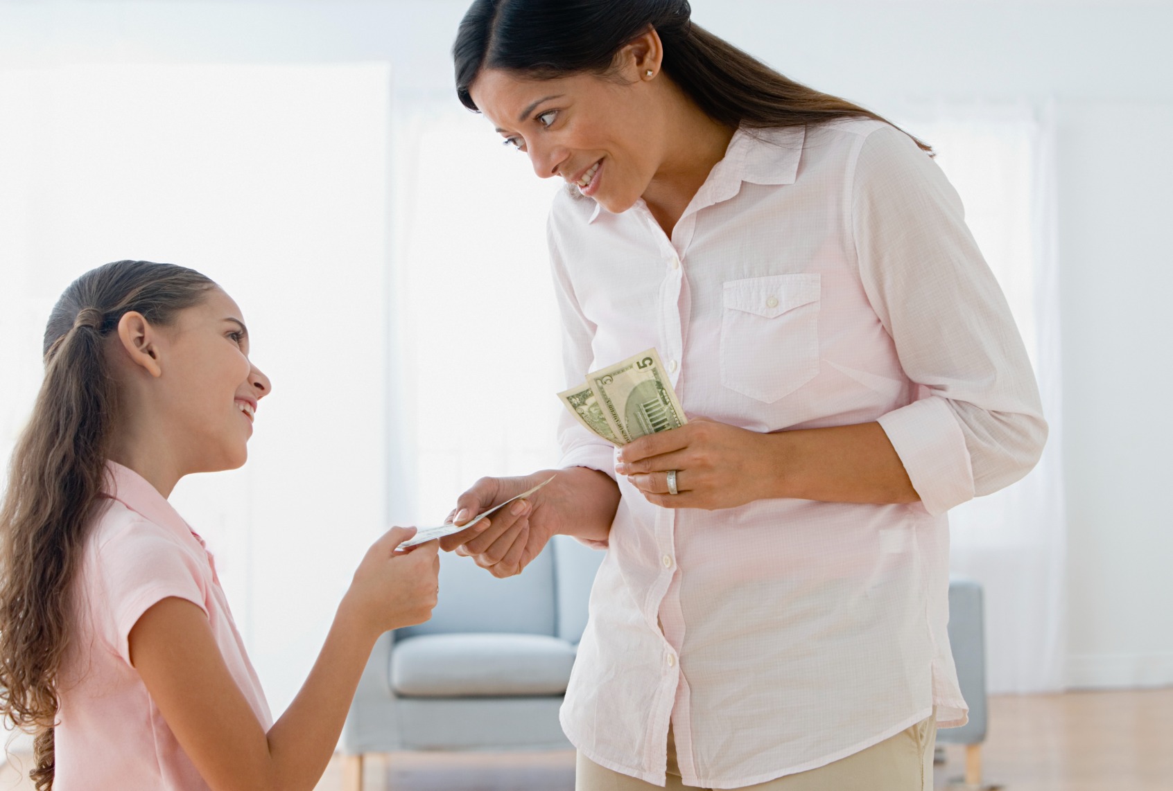Mom giving daughter money. (Getty Images/Image Source)