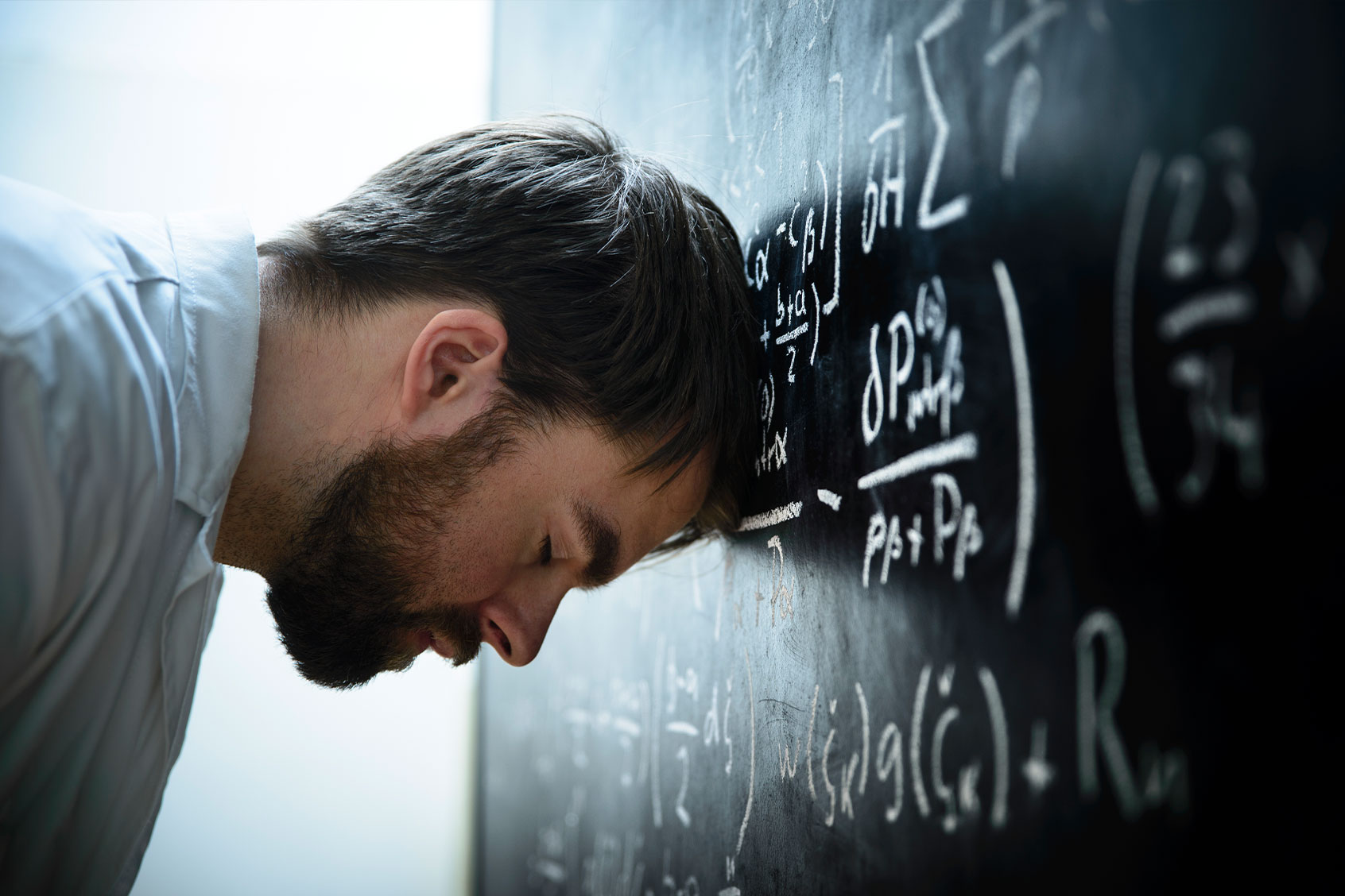 A scientist in front of a blackboard filled with formulas and equations (Getty Images/nicolas_)