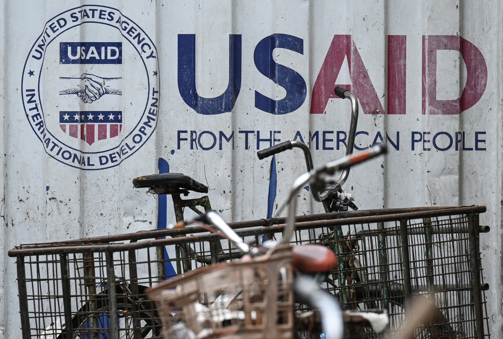 Signage for the US government's humanitarian agency USAID is seen on a cargo container beside a tricycle in Manila on February 4, 2025. (JAM STA ROSA/AFP via Getty Images)