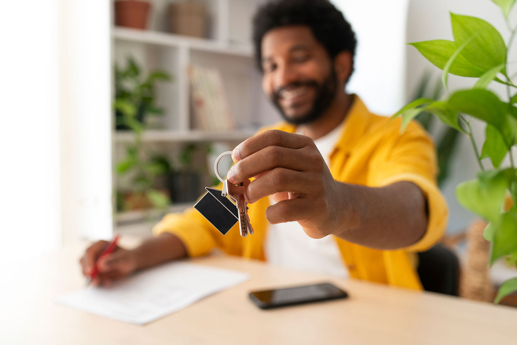 Young man holding keys after buying new house (Getty Images/Westend61)